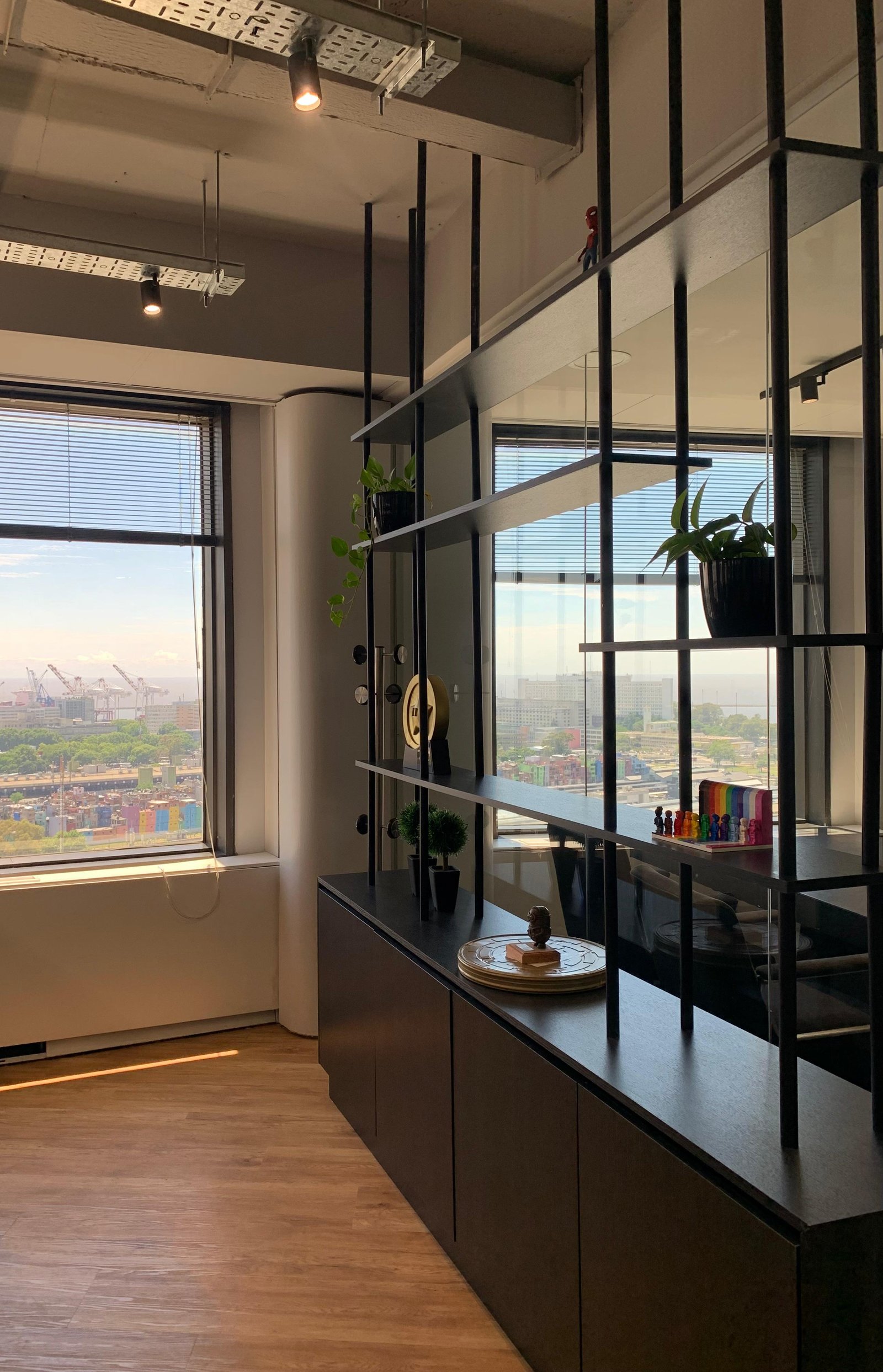 Oficina moderna con amplias ventanas y estanterías de metal negro — proyecto Oficinas UIP, por cromo., en Retiro